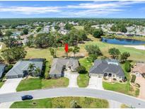 Beautiful golf course home with lush landscaping, large driveway, and mature trees near a pond at 9216 Tarleton Cir, Weeki Wachee, FL 34613