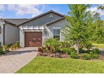 Charming single-story home featuring a manicured lawn, neat landscaping, and an attached garage at 16793 Forge Surf St, Land O Lakes, FL 34638
