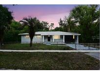 Charming single-story home with a well-maintained lawn, mature trees, and freshly painted exterior at dusk at 18838 Rosephil St, Spring Hill, FL 34610