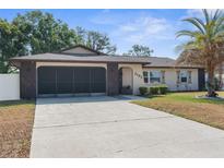 Charming one-story home with a well-manicured lawn and a spacious driveway and two car garage at 2192 Meredith Dr, Spring Hill, FL 34608