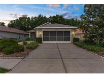 Charming home featuring a well-kept lawn, two-car garage, and welcoming curb appeal at 261 Rochester St, Spring Hill, FL 34609