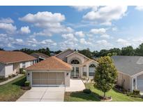 Charming single-story home featuring an attached two-car garage and well-manicured front lawn at 284 Quane Ave, Spring Hill, FL 34609