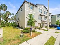 Townhome with manicured lawn, attached garage, and sidewalk leading to the front door at 4740 Tuscan Loon Dr, Tampa, FL 33619