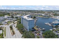Stunning aerial view of waterfront condo building with boat docks and beautiful blue waters and surrounding community at 4939 Floramar Ter # 902, New Port Richey, FL 34652
