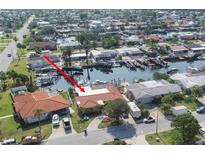 Waterfront property with a private dock, mature landscaping, and tile roof at 5008 Forecastle Dr, New Port Richey, FL 34652