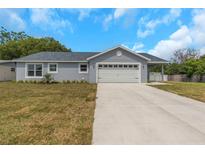 Charming single-story home featuring a two-car garage, landscaped yard and covered front porch at 5214 Idlewild St, New Port Richey, FL 34653