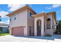 Two-story stucco house with a brown garage door and a covered front entry with stairs at 6340 Spoonbill Dr, New Port Richey, FL 34652