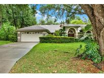 Charming single-story home with a well-manicured lawn and mature trees providing shade at 642 Erin Way, Brooksville, FL 34601