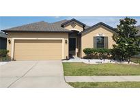 Charming single-story home with well-maintained landscaping, complemented by a two-car garage and neutral exterior at 954 Old Windsor Way, Spring Hill, FL 34609