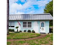 Charming single-story home with a well-manicured lawn, metal roof, and an inviting entryway with lovely shrubbery at 11631 Bayonet Ln, New Port Richey, FL 34654