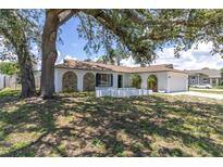 Charming home featuring an arched entryway and stone accents at 1402 Tallahassee Dr, Tarpon Springs, FL 34689