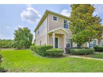 Charming townhouse featuring a well-maintained lawn, manicured bushes, and a welcoming front entrance at 15846 Stable Run Dr, Spring Hill, FL 34610