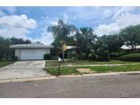 Charming single-story home with a well-maintained front yard and mature landscaping at 2083 Envoy Ct, Clearwater, FL 33764