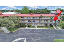 A sunny view of the condo's exterior showing the multiple units with a red roof and well maintained lawns at 2402 Ecuadorian Way # 40, Clearwater, FL 33763