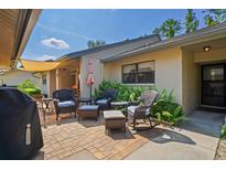 Relaxing patio area with comfortable wicker furniture, an outdoor grill, and lush greenery around the outside wall at 3274 Lori Ln # 2, New Port Richey, FL 34655