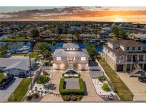 Stunning waterfront home with lush landscaping, brick driveway, and attached garages at sunset at 3352 Gulfview Dr, Hernando Beach, FL 34607