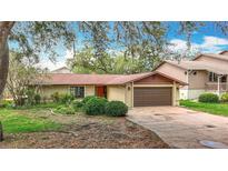 Charming single-story home featuring a brown roof, two-car garage, and front yard landscaping at 4420 Marine Pkwy, New Port Richey, FL 34652