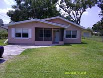 Charming single-story home featuring a screened front porch, well-maintained lawn, and inviting curb appeal at 7419 E Comanche Ave, Tampa, FL 33610