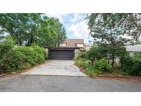 Charming home featuring a garage, driveway, and mature landscaping for added privacy and curb appeal at 7501 Woodbox Row, Hudson, FL 34667