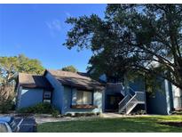 Blue condo building with white staircase and a large tree in the front yard with lush green grass at 7600 St. Andrews Blvd # 7600, Weeki Wachee, FL 34613