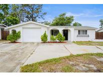 Charming single-story home with a well-maintained yard, arched entryway, and a one-car garage at 9111 Greenbriar Ln, Port Richey, FL 34668
