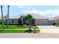 Charming single-story home with a manicured lawn, three-car garage, and inviting curb appeal at 9810 Compass Point Way, Tampa, FL 33615