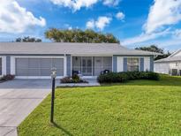 Charming single-story home with a screened-in porch, manicured lawn, and lovely landscaping at 11141 Sandtrap Dr # 11141, Port Richey, FL 34668