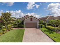 Charming home featuring a brick driveway, manicured lawn, and lush landscaping at 11611 Callisia Dr, Odessa, FL 33556