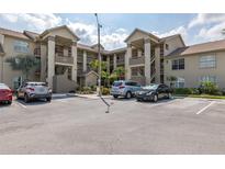 Condo building exterior featuring assigned parking, multiple stories, staircases, and neutral paint at 4575 Whitton Way # 1132, New Port Richey, FL 34653