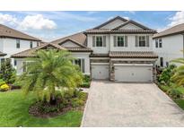 Elegant two-story home featuring a neutral color palette, tile roof, three-car garage and professionally landscaped yard at 5001 Night Star Trl, Odessa, FL 33556