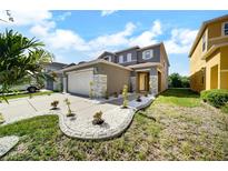 Charming two-story home featuring a well-manicured lawn and a two-car garage at 6222 Cherry Blossom Trl, Gibsonton, FL 33534