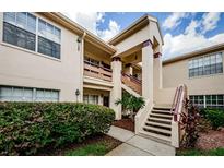 Inviting condo exterior featuring manicured landscaping and a well-maintained facade with stairs at 7807 Hardwick Dr # 123, New Port Richey, FL 34653