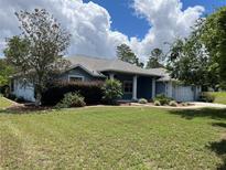 Charming single-story home featuring a well-manicured lawn, mature landscaping, and a welcoming front entrance at 10054 Hernando Ridge Rd, Weeki Wachee, FL 34613