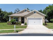 Charming single-story home with a two-car garage, well-maintained lawn, and colorful landscaping at 11308 Mollymawk Ct, New Port Richey, FL 34654