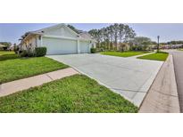 Large driveway leads to a well-maintained home with a spacious two-car garage at 11389 Mcnally Dr, Spring Hill, FL 34609