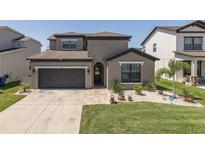 Beautiful two-story home featuring a well-manicured lawn and a spacious two-car garage at 12750 Tikal Way, Trinity, FL 34655