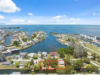 Beautiful aerial view of waterfront community with a view of the water and a property outlined in red at 14220 Hendry Ct, Hudson, FL 34667