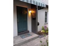 Inviting front entryway featuring a teal door with a 'Welcome' mat and a decorative awning at 441 75Th N Ave # 441, St Petersburg, FL 33702