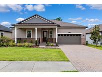 Charming single-story home with a covered front porch, manicured lawn, and two-car garage at 5005 Southern Valley Loop, Brooksville, FL 34601