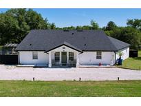 Charming one-story home with a new dark roof, white exterior, and a gravel front yard at 6158 Sumter Dr, Brooksville, FL 34602