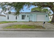 Charming light blue home featuring a garage and a quaint arched doorway at 9744 Rainelle Ln, Port Richey, FL 34668