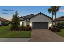 A charming home featuring a well-manicured lawn and a spacious driveway, showcasing its inviting curb appeal at 11398 Juglans Dr, Odessa, FL 33556