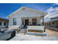 Charming white brick home with a cozy front porch and manicured landscaping at 124 Athens St, Tarpon Springs, FL 34689
