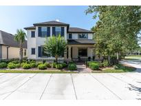 Charming two-story home with a well-manicured lawn, dark shutters, and a welcoming front porch at 12420 Rangeland Blvd, Odessa, FL 33556