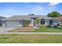 Charming single-story home featuring manicured landscaping, a two-car garage, and inviting curb appeal at 1245 Overland Dr, Spring Hill, FL 34608