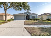 Charming single-story home featuring a two-car garage, arched entryway, and a well-maintained front lawn at 15159 Durango Cir, Brooksville, FL 34604