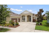 Beautiful single-story home with a well-manicured front yard and a three-car garage at 16697 Courtyard Loop, Land O Lakes, FL 34638