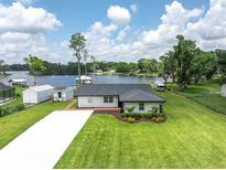 Charming lakeside home features manicured lawn, updated roof, and picturesque water views at 18102 Spencer Rd, Odessa, FL 33556