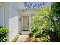Inviting front entrance with a neutral-colored door, well-maintained garden, and clearly visible address at 2836 Featherstone # 2836, Holiday, FL 34691