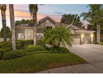 Charming single-story home with lush landscaping, a well-manicured lawn, and a three-car garage at 3243 Stonegate Falls Dr, Land O Lakes, FL 34638
